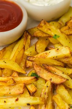 french fries with ketchup and mayonnaise on a white plate next to dipping sauce