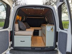 the interior of a camper van with its door open and storage drawers in place