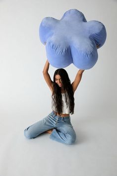 a woman is sitting on the floor with an inflatable cloud above her head