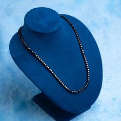 a blue hat with a beaded necklace on it