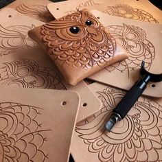 a pair of scissors sitting on top of some brown leather coasters with intricate designs