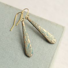 These beautiful earrings feature a filigree floral design in solid brass.  The curved botanical engraving remind us of classic Art Nouveau design.   The earwires are also solid brass, and the length of these earrings is 40mm (just less than inches), with the floral drop designed to hang just below the earlobe.   This piece of handmade jewellery comes packaged in a nice recycled gift box with a handmade tag, all ready to give or keep. 🖤 FASTER SHIPPING 🖤 Need this fast? We offer a Faster Shippi Vintage Teardrop Earrings With Ear Wire For Gift, Gold Earrings With Patina As A Gift, Gold Earrings With Patina For Gift, Patina Drop Earrings As Gift, Vintage Patina Earrings, Vintage Teardrop Patina Earrings, Turquoise Filigree Earrings For Gift, Turquoise Filigree Earrings As Gift, Elegant Patina Earrings For Gifts