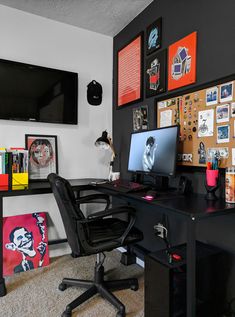 a desk with a computer on top of it in front of a wall full of pictures