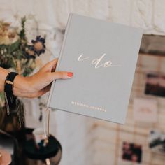 a person holding up a wedding journal