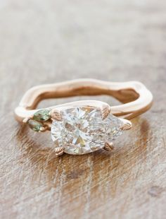 a pear shaped diamond ring on a wooden surface