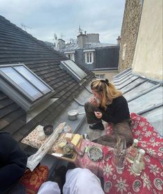 a woman sitting on top of a roof eating food