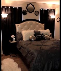 a bedroom with black and white decor on the walls, bedding, and pillows