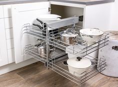 an open dish rack with pots and pans in the middle of a kitchen counter