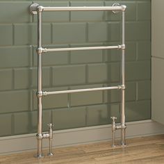 an image of a towel rack on the floor in front of a green brick wall