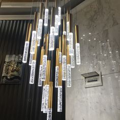 a chandelier made out of gold and white glass tubes hanging from the ceiling