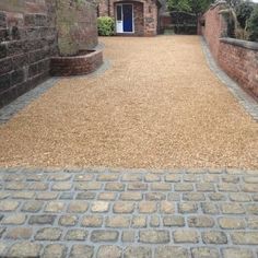 an old brick building with a walkway leading up to it and a blue door in the background