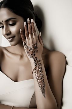 a woman with henna tattoos on her arm and hand is posing for the camera