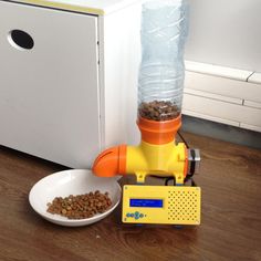 a dog food dispenser next to a bowl of water