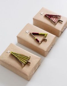 three wrapped christmas tree ornaments sitting on top of each other in brown paper with white stars