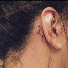 a woman with a small tattoo behind her ear