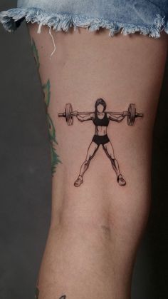 a woman with a barbell tattoo on her leg