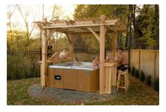 two people sitting in an outdoor hot tub under a pergolated gazebo with the sun shining on them