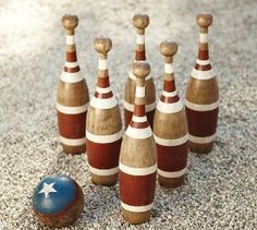 several bowling pins and an american flag on the ground next to some other items that have been made out of wood