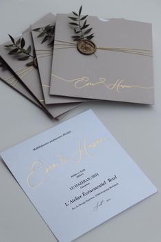 three wedding cards with gold foil on them