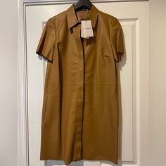 One Of A Kind Absolutely New With Tags And Security Tags Button Down Leather Dress In Cognac Color (Brown/ Tan) With Pockets. Unique In Every Way And A Lifetime Purchase! You Will Be The Best Dressed Person In The Room, Always. Size M. Classic & Timeless. Brown Shirt Dress For Workwear, Brown Shirt Dress For Work, Brown Short Sleeve Shirt Dress For Work, Chic Brown Dresses With Button Closure, Brown Midi Dress With Button Closure For Work, Chic Beige Dress With Placket, Brown Short Sleeve Shirt Dress For Fall, Spring Leather Dresses With Button Closure, Collared Brown Dress For Work