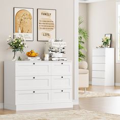 a living room with white furniture and pictures on the wall above it's dresser