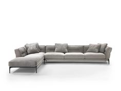 a gray sectional couch with pillows on it's back and side facing each other