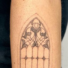 a tattoo on the leg of a person with a stained glass window in it's center