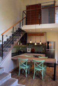 a kitchen and dining area with stairs leading up to the second floor