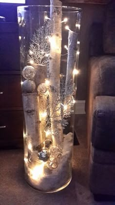 a tall glass vase filled with lights and snow flakes on top of a carpeted floor