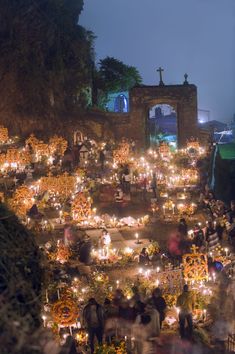 many people are standing around with candles in their hands