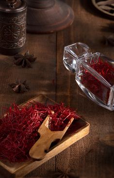 red saffron in a wooden box next to a pair of scissors on a table