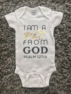 a baby bodysuit with the words i am a girl from god in gold on it