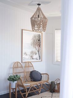 a wicker bench in the corner of a room with white walls and wooden shutters