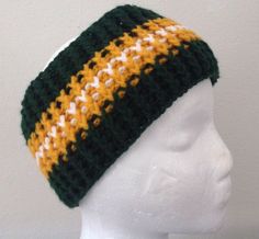 a white mannequin head wearing a green, yellow and white knitted hat