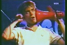 a man holding a red megaphone up to his ear