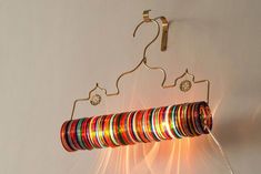 a multicolored bracelet hanging from a hook on a wall