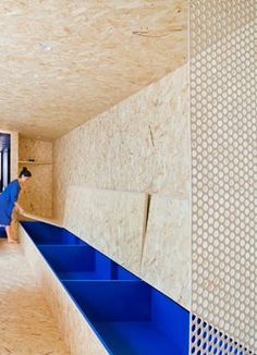 a woman is standing in the middle of a room that has blue shelves on it