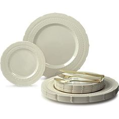 white dinnerware set with gold trimmings on the edge and plates in front