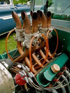 the engine compartment of an old car with many pipes and valves on it's side