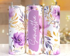 three personalized tumbles with floral designs and the word happy birthday on one side