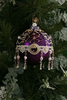 a purple ornament hanging from a christmas tree