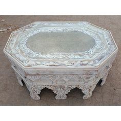 an old white wooden table sitting on the ground