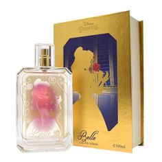 the perfume bottle is next to an open book with a pink rose in it and a gold box behind it