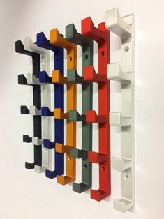 a multicolored wall mounted shelf with hooks