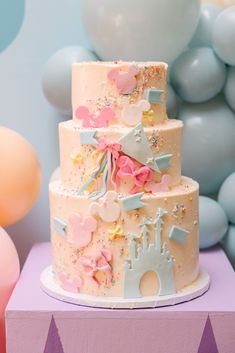 a three tiered cake is decorated with pastel colors and confetti decorations