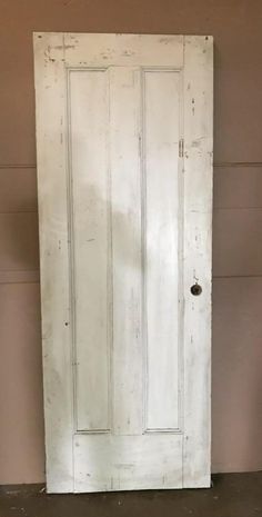 an old white door in the corner of a room