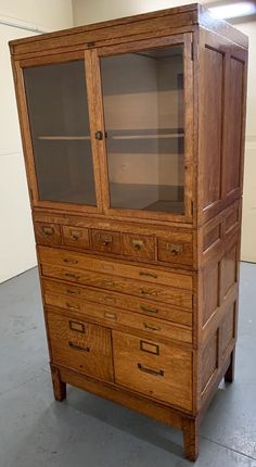 an old wooden cabinet with glass doors and drawers