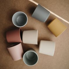 four different colored cups sitting next to each other