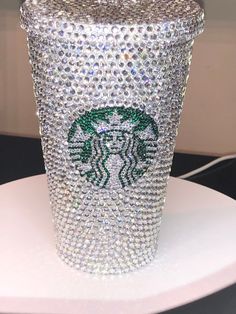 a starbucks cup covered in lots of swarozavs on top of a white stand