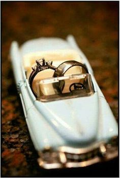 two wedding rings sitting on top of a toy car